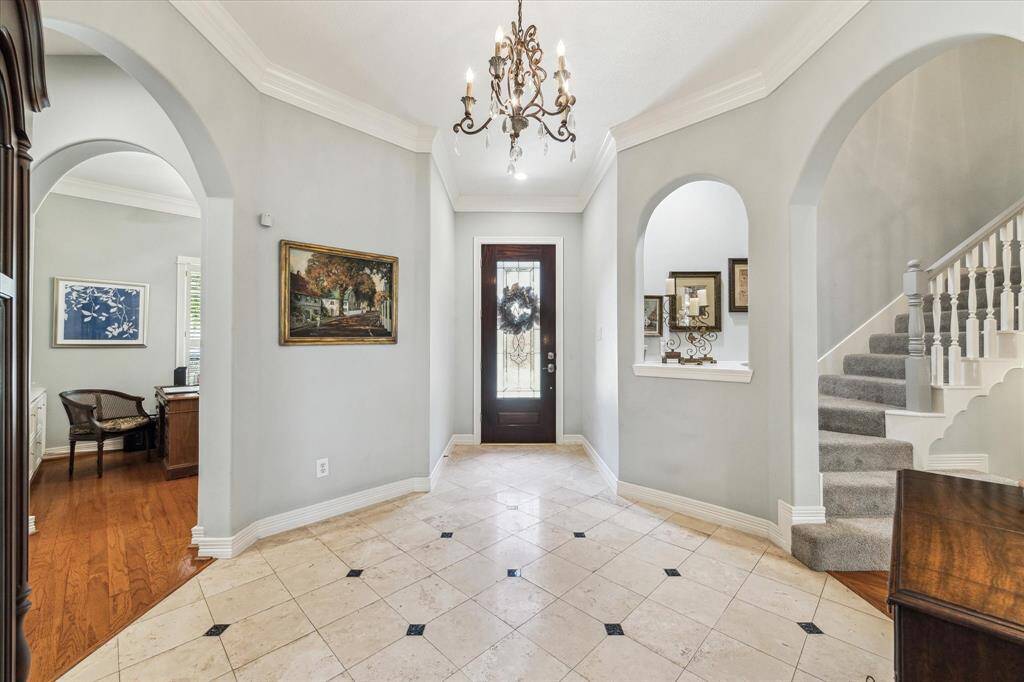 Entry shows off  the wonderful architectural design with curved doorways and accents and beautiful flooring.