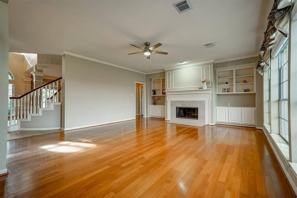 This family room complemented by built-in bookshelves that provide both style and functionality. New ceiling fans enhance comfort year-round.