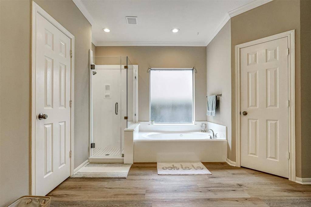 The ensuite bathroom features upgraded quartz countertops, dual new sinks with sleek, modern faucets, and a beautifully appointed shower room.
