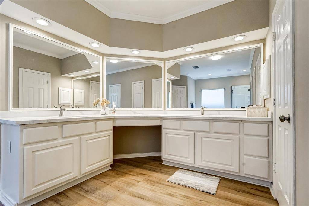 Waterproof luxury vinyl plank flooring adds both elegance and durability, while bright LED lighting enhances the clean, contemporary feel.