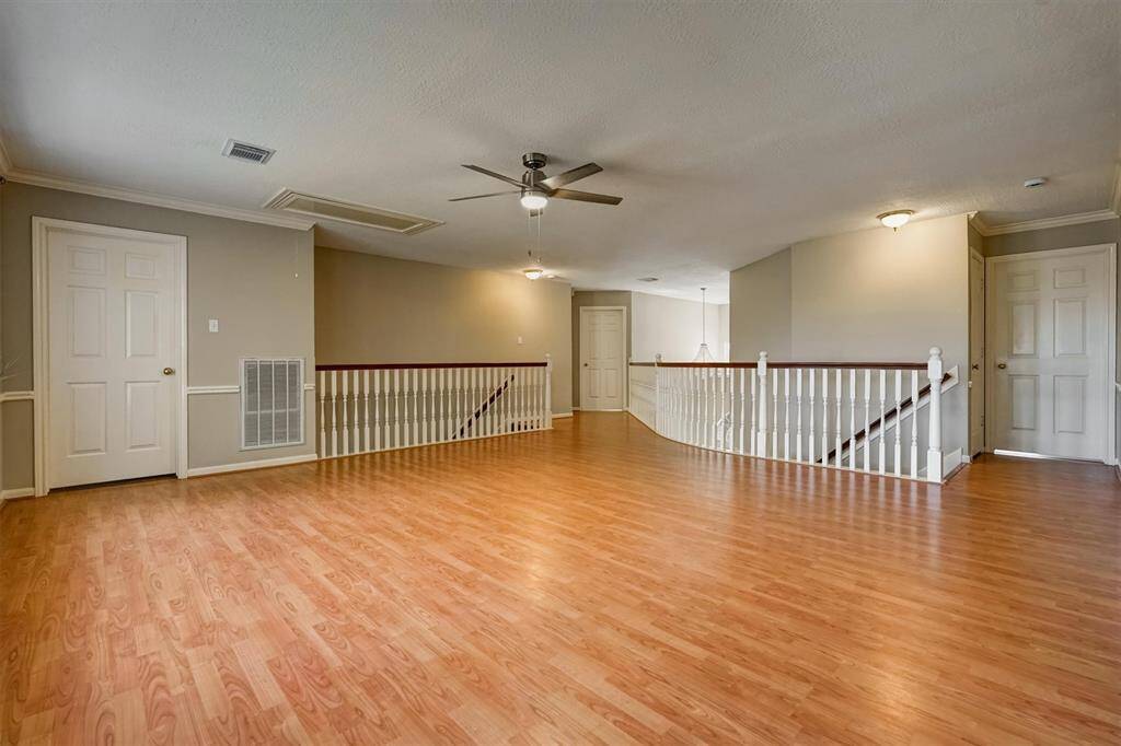 Two staircases help access the upstairs game room easily. This generous game room offers plenty of space for fun and entertainment, easily accommodating both a pool table and table tennis setup.