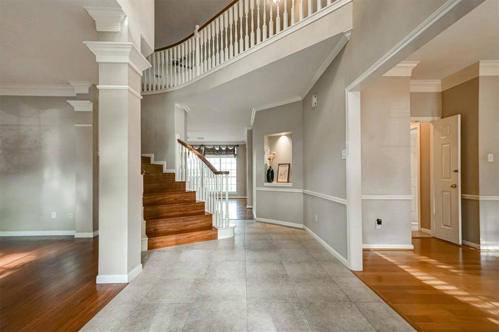 Step through the front door into a breathtaking foyer featuring soaring high ceilings. The spacious entryway creates an immediate sense of openness and sophistication, seamlessly flowing into the formal living and dining rooms. The living room can be used for study or entertaining area.