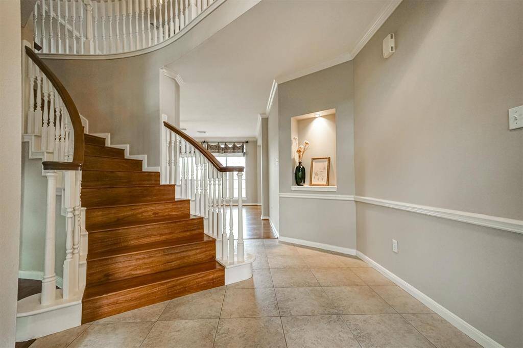 Hallway connecting to family room and the beautifully crafted spiral staircase leading to the upper level