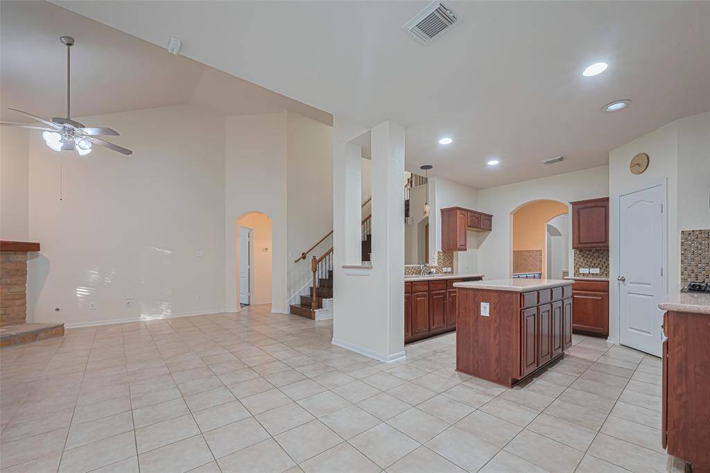 This kitchen is by far any chef’s dream! This spacious kitchen features high ceilings, dark stained wood cabinets, granite countertops, modern tile backsplash, recessed lighting, kitchen island,  double sink and space for breakfast bar and a large pantry all overlooking your huge family room.