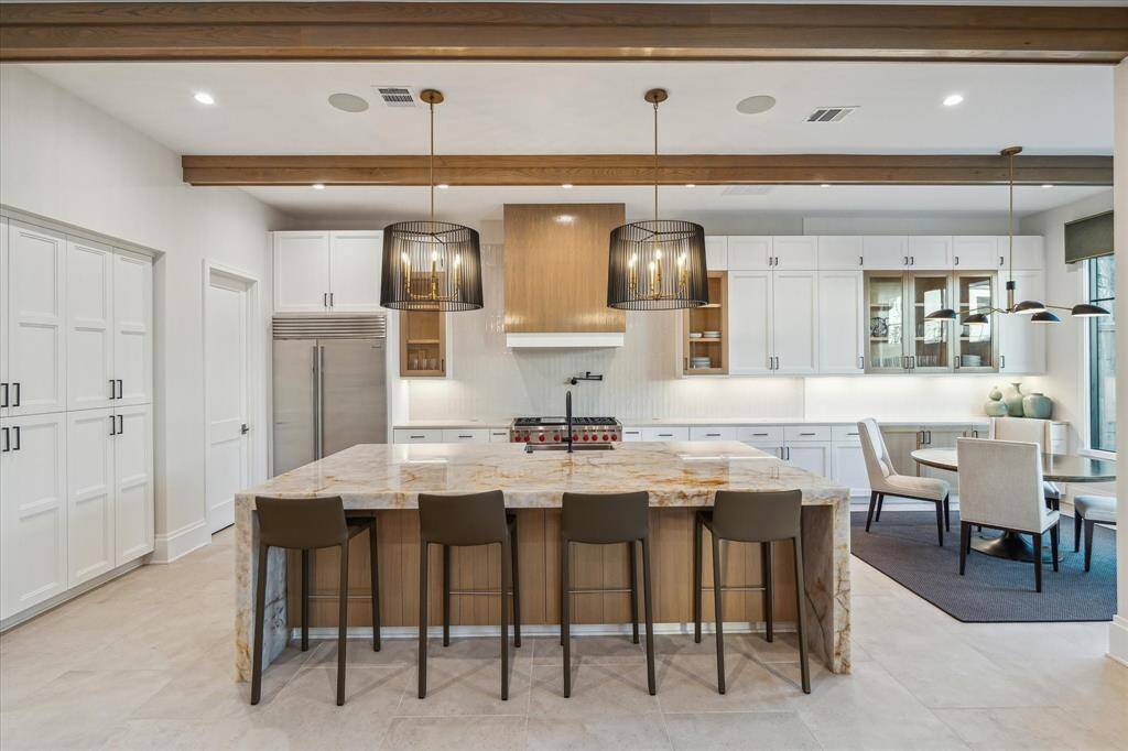 The kitchen’s thoughtful layout offers convenient access to the wet bar and walk-in pantry. Its seamless design ensures smooth entertaining and everyday functionality.