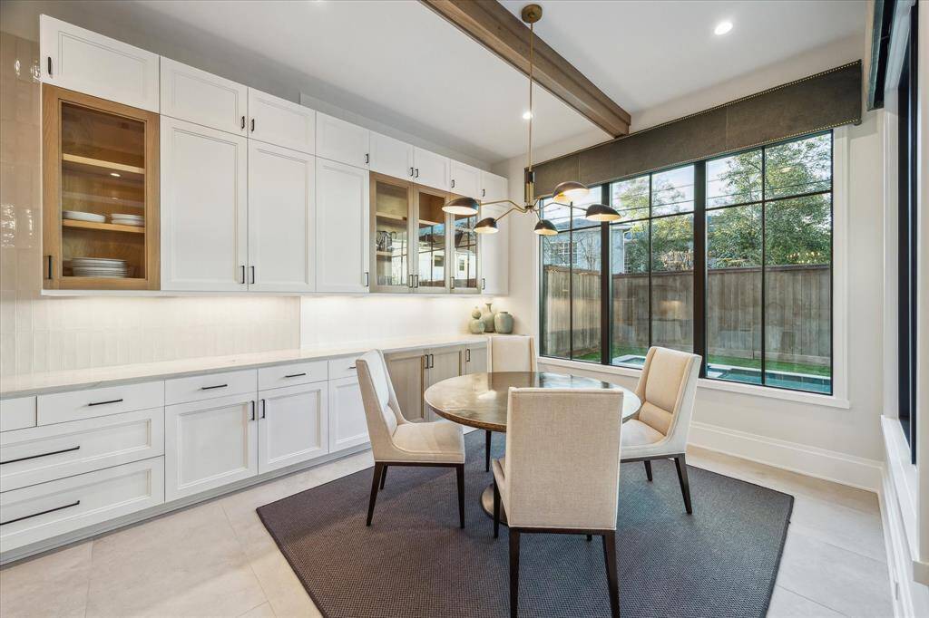 The breakfast room’s dual walls of windows provide serene views of the covered patio and pool area. This inviting space is ideal for casual meals or morning coffee in a bright and airy setting.