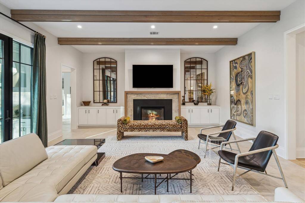 Anchored by a quartzite fireplace surround and white oak mantel, the family room offers warmth and sophistication. Dual custom built-ins flank the fireplace, providing both storage and a stylish display for curated décor.