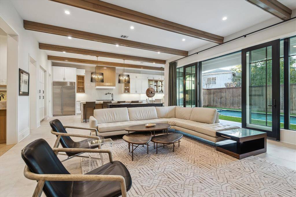 The spacious family room offers seamless connectivity to the kitchen and pool area, blending indoor and outdoor living. Sliding glass doors frame views of the backyard oasis, creating a relaxed yet sophisticated ambiance.