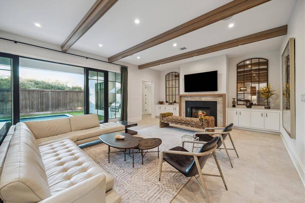 The family room’s dual built-ins, elegant fireplace, and refined finishes offer warmth and character. Expansive windows invite natural light, creating an inviting and versatile space for relaxation and entertaining.