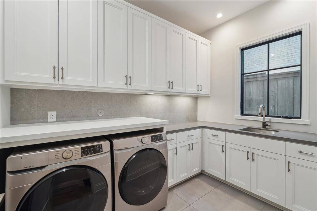 The first-floor utility room combines quartz countertops, Samsung appliances, and ample cabinetry. Its layout offers functionality without sacrificing style.