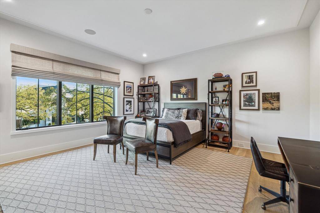 Guest bedroom #1 offers engineered white oak flooring, a designer ceiling accent, and custom blackout window coverings. This inviting space combines comfort with sophisticated design.