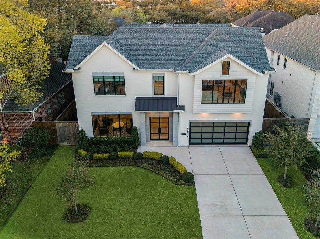 This striking aerial view showcases the home's impressive facade, manicured landscaping, and expansive lot. The blend of brick and cement board exterior, paired with lush greenery, reflects the home's refined elegance. Its thoughtfully designed layout offers a glimpse of the luxurious interiors within.