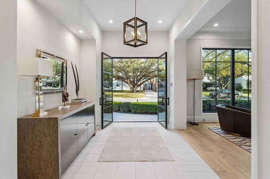 Framed by custom French front doors, the view from the foyer reveals the lush front lawn and manicured landscaping. This stunning perspective blends indoor elegance with outdoor charm, creating a welcoming first impression.