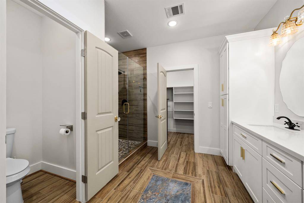 Primary bathroom has stunning tiling, new built-ins, and a completely fresh look.