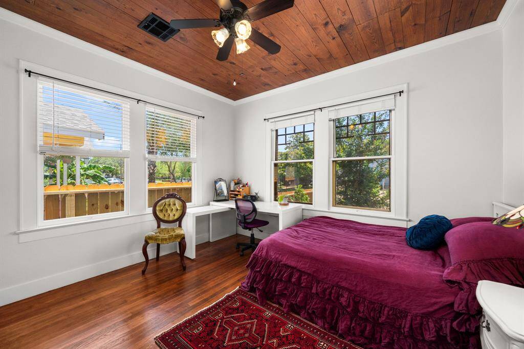 The secondary bedroom with the same flooring continuing and a whole lot of natural light coming into the room.