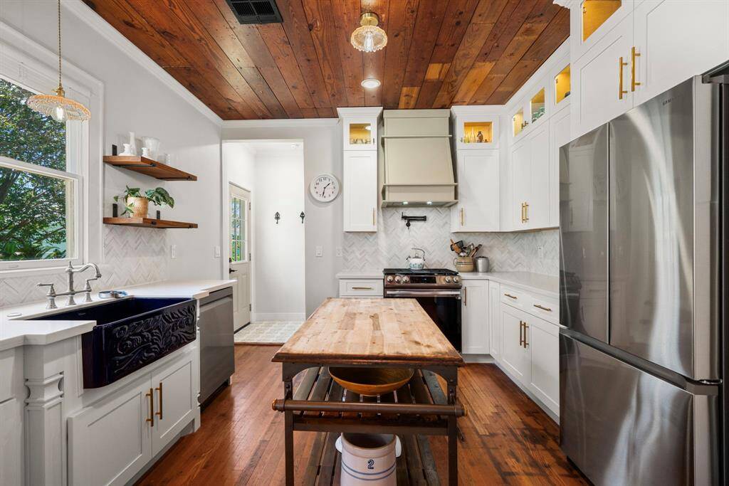 Kitchen has updated quartz countertops, gas range, and a farm sink,