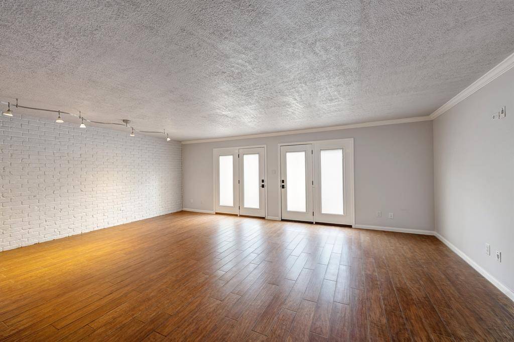 Empty family room with brick wall/ French doors to patio and parking