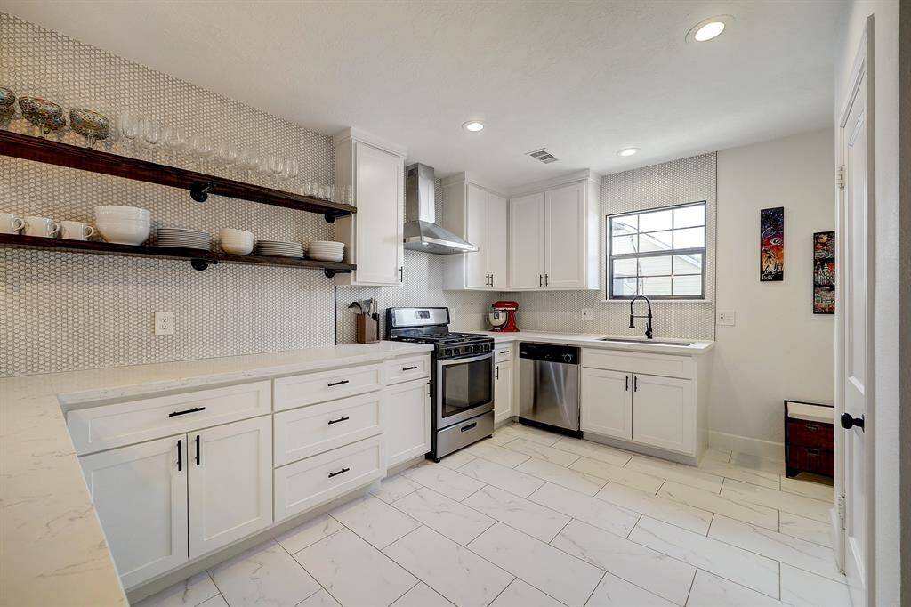 The kitchen boasts tons of counter space. lots of cabinets, and has a fresh and clean look.