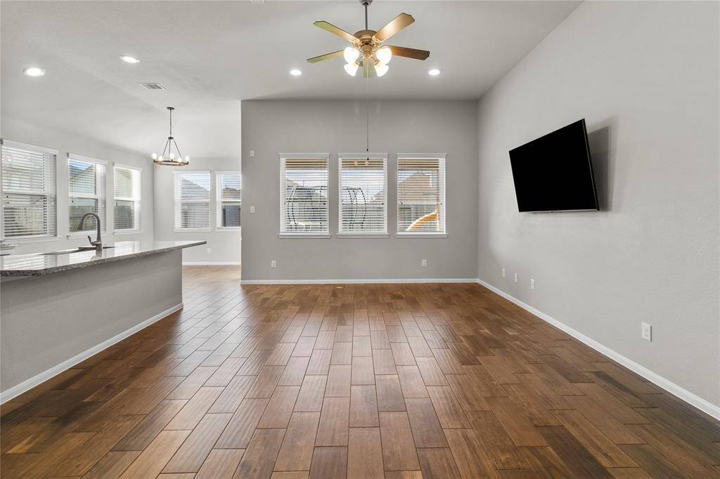Natural light pours into this large open living space, highlighting the beautiful floors.