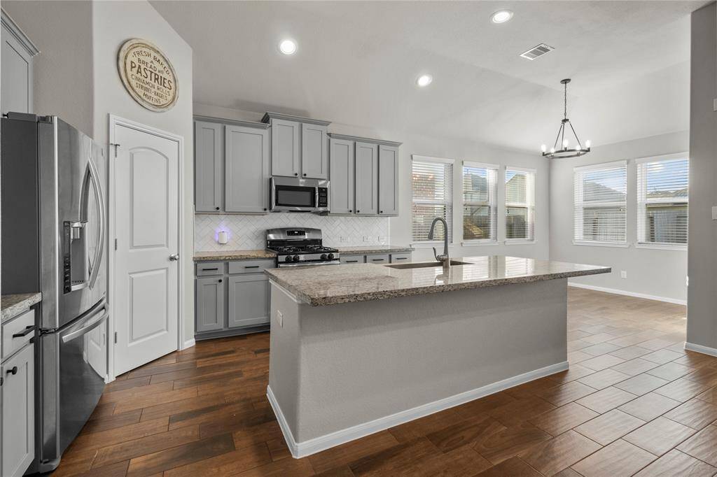 Well-appointed kitchen with granite surfaces, gas cooking, and stylish tile backsplash—perfect for everyday living and entertaining.