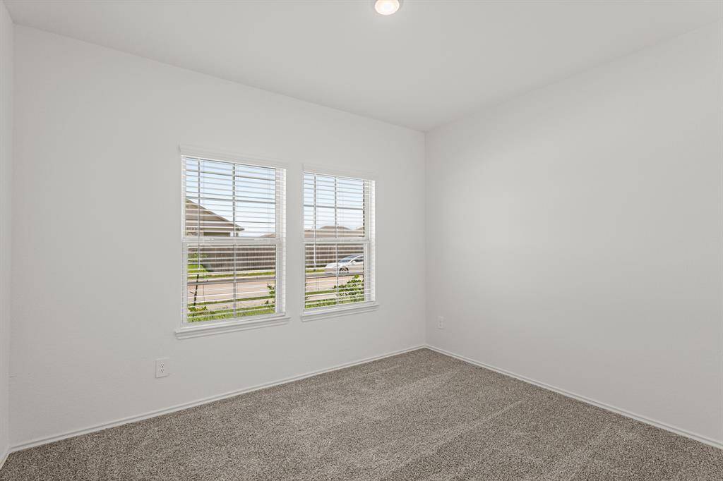 Bright and inviting, this downstairs secondary bedroom offers plenty of room for relaxation and personalization, and it's located just off the downstairs full bath, making it the perfect retreat for family or guests.