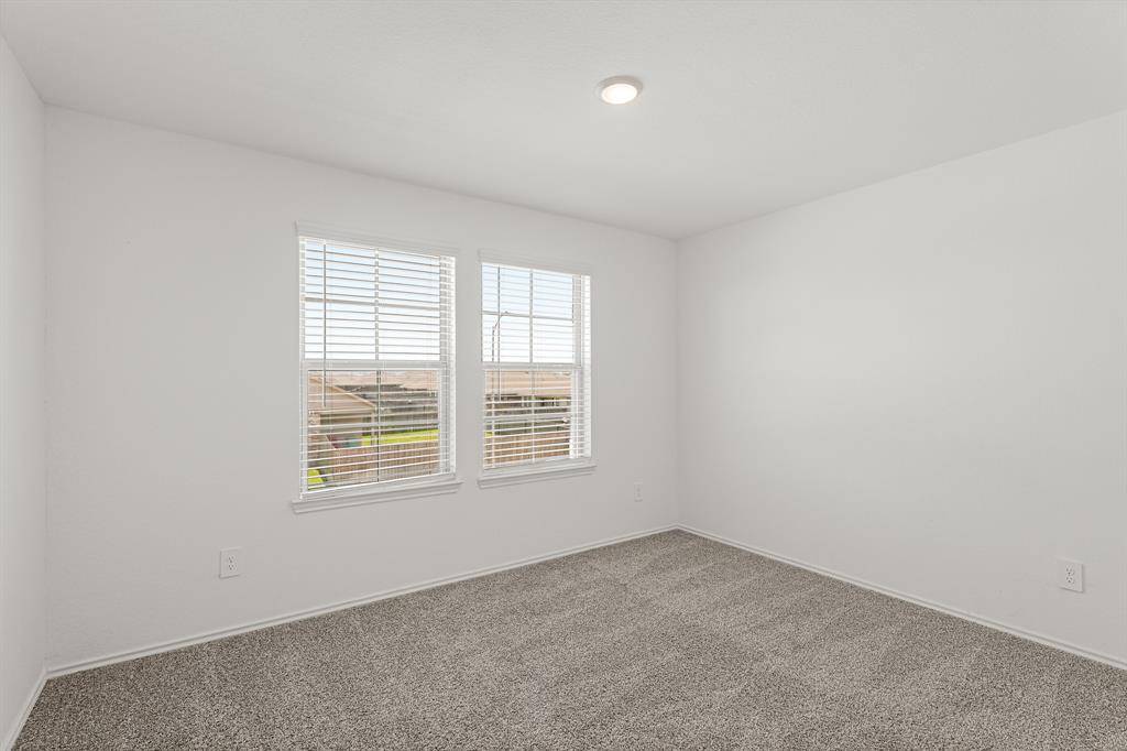 Another spacious secondary bedroom featuring bright natural light, LED lighting, plush carpet, and large closet.