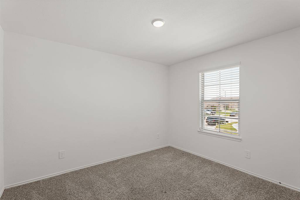 Final secondary bedroom featuring bright natural light, plush carpet, neutral paint, and spacious closet.