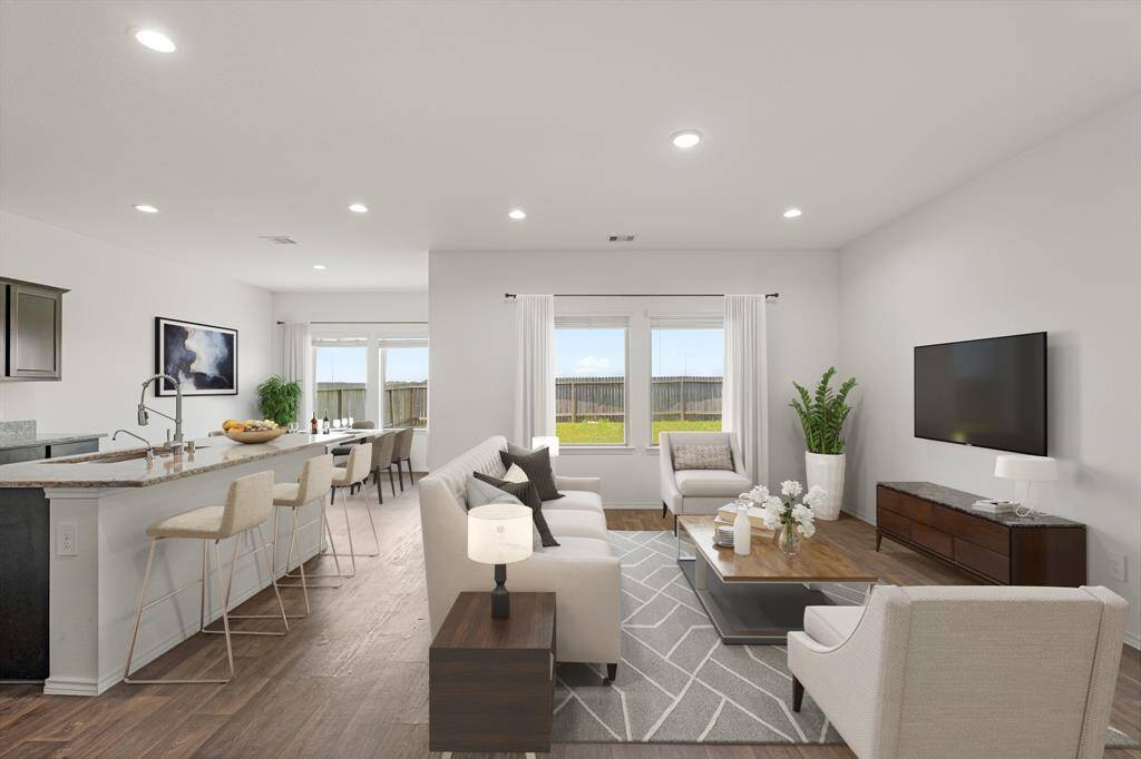 Whether it's a simple night in or entertaining family and friends, this home has ample open space for everyone to enjoy! Featuring recessed lighting, bright natural light, and luxurious wood look floors this living space offers it all. *This photo has been virtually staged