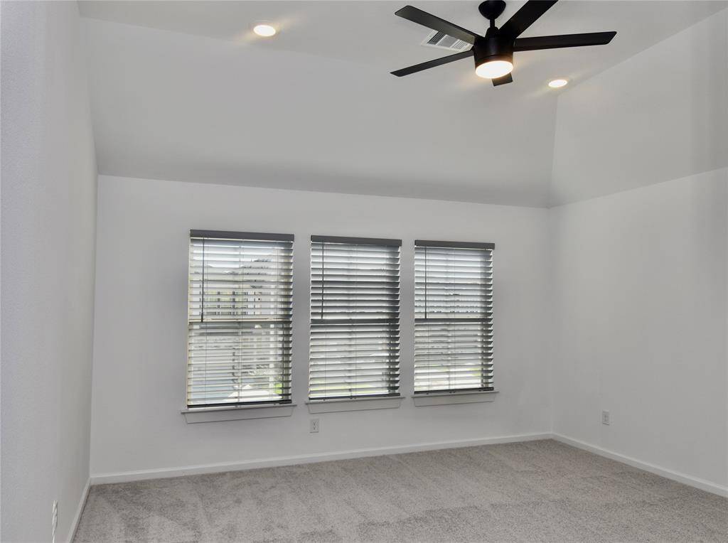 Primary Suite featuring custom blinds and remote cintroled ceiling fan and light
