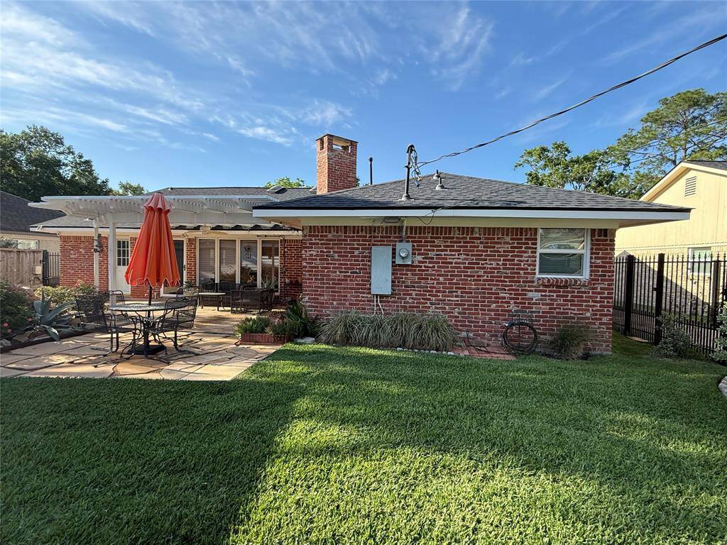 Rear elevation with custom-built, partially covered, and expanded patio.
