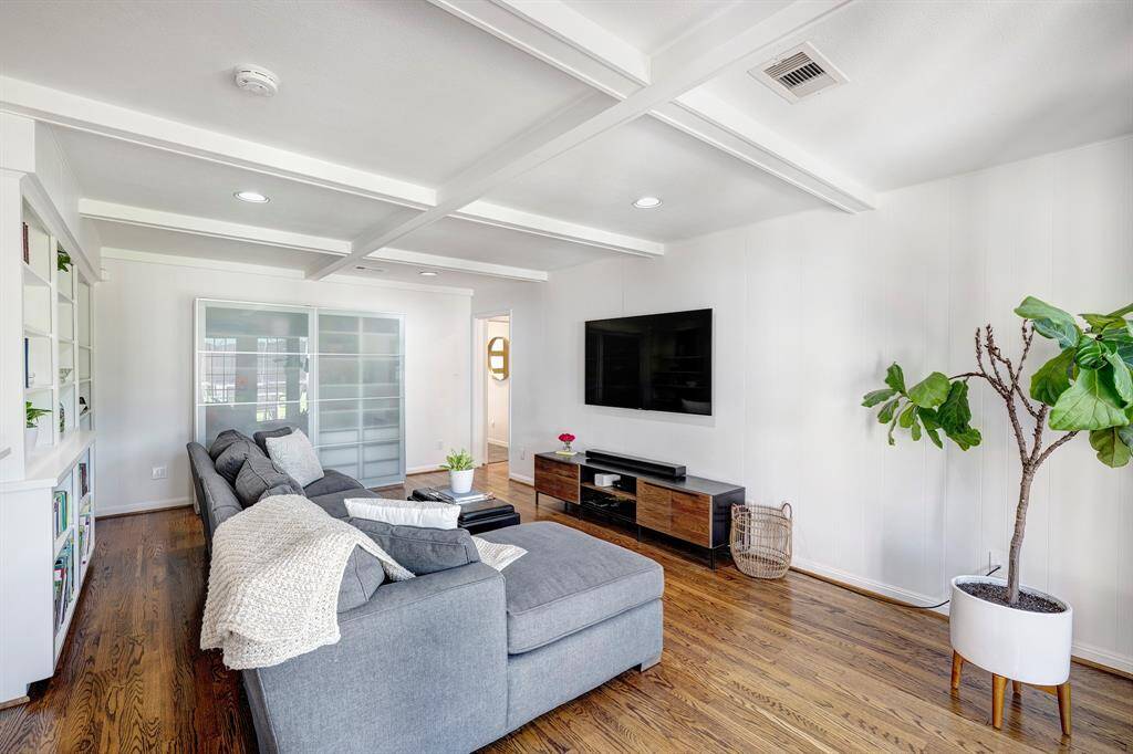 Cozy family room with built-in bookshelves, coffered ceiling and French doors overlooking the backyard
