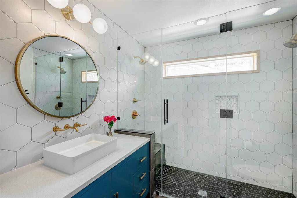 Stylish primary bath with double shower and quartz countertops