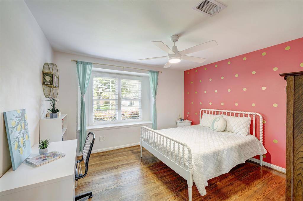 Secondary bedroom with bay window, hardwood floors and new ceiling fan