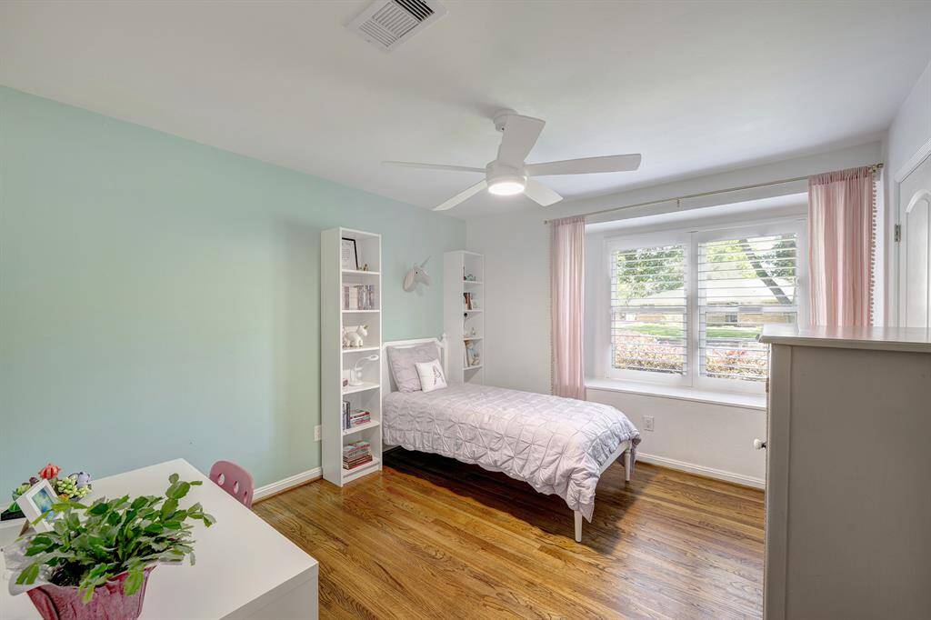 Secondary bedroom with bay window, hardwood floors and new ceiling fan