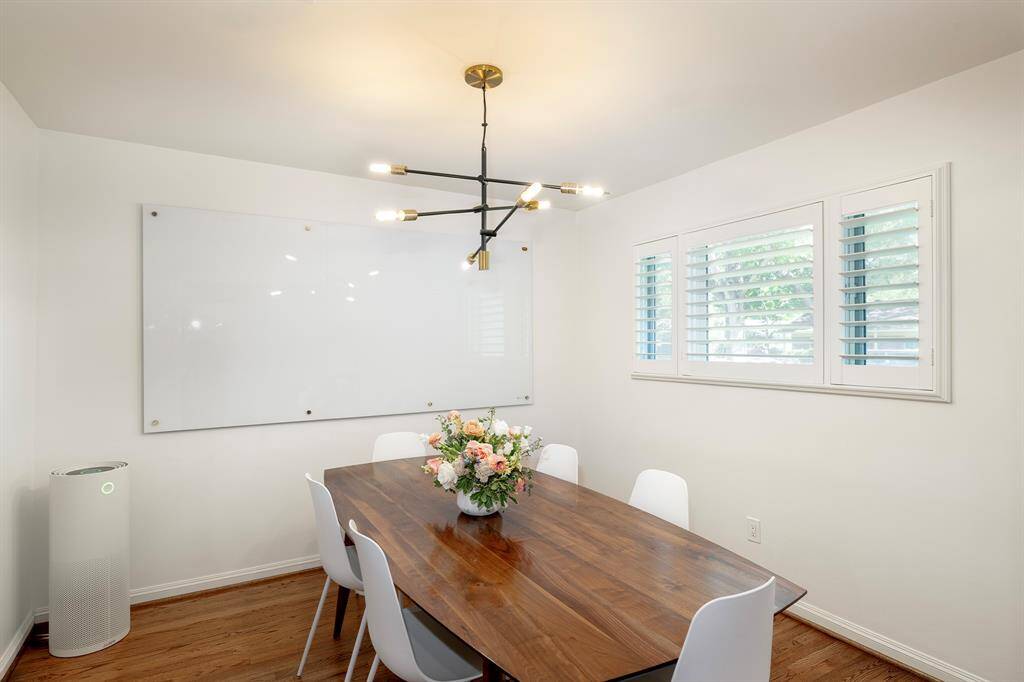 Formal dining with plantation shutters and cute mid-century light fixture