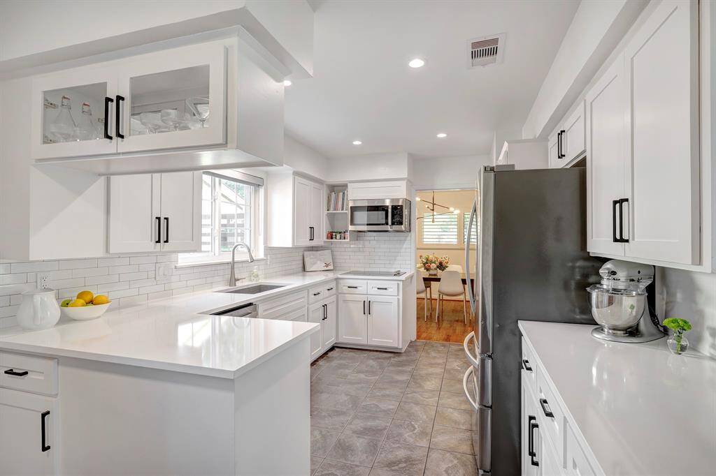 View from the breakfast nook of the newly remodeled kitchen with quartz countertops and sleek electric cooktop. Gas hookup is available for a gas cooktop as well.
