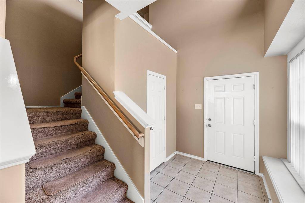 The foyer features elegant tile flooring, offering a polished and practical entrance that sets the tone for the rest of the home.