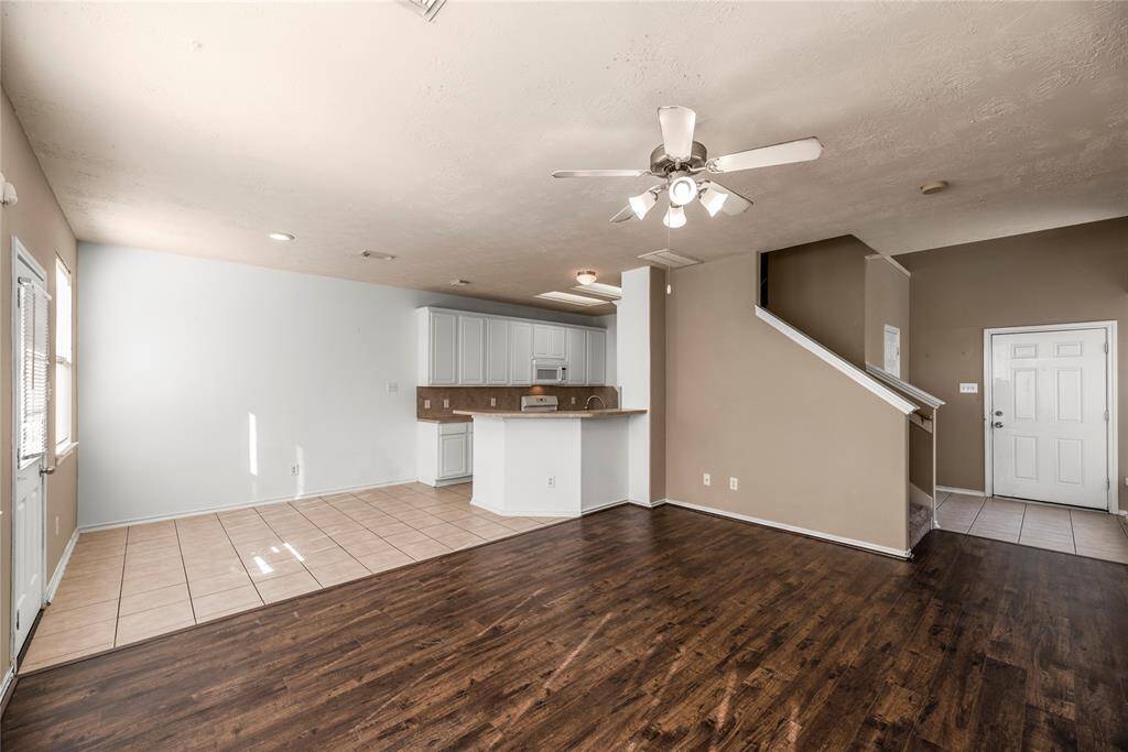 The generous living area offers ample space to relax and unwind, complemented by a stylish ceiling fan that enhances comfort and airflow year-round.