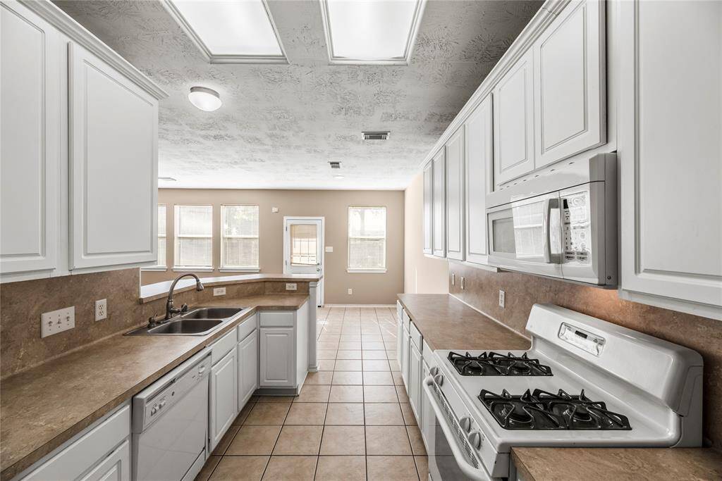 Featuring easy care tile flooring and crisp white cabinetry, the space exudes a fresh, clean aesthetic that blends timeless elegance with modern charm.