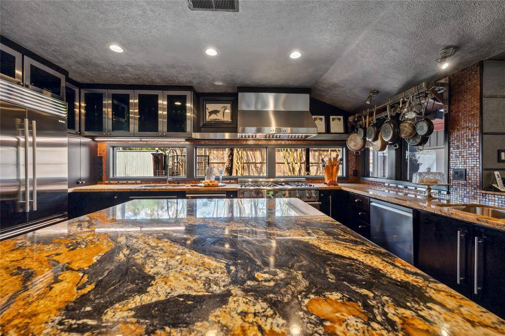 Kitchen with stunning granite counters and plenty of light from the abundance of windows.