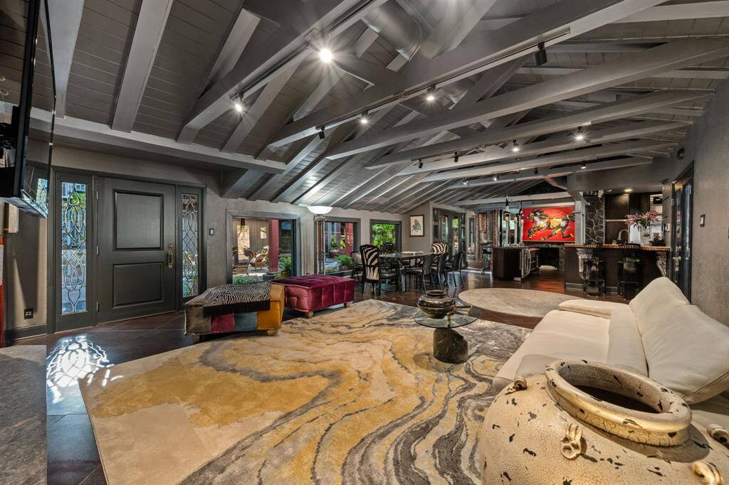 An alternate view into the den showcases its cozy, welcoming ambiance, with large windows framing picturesque views of the courtyard and backyard.