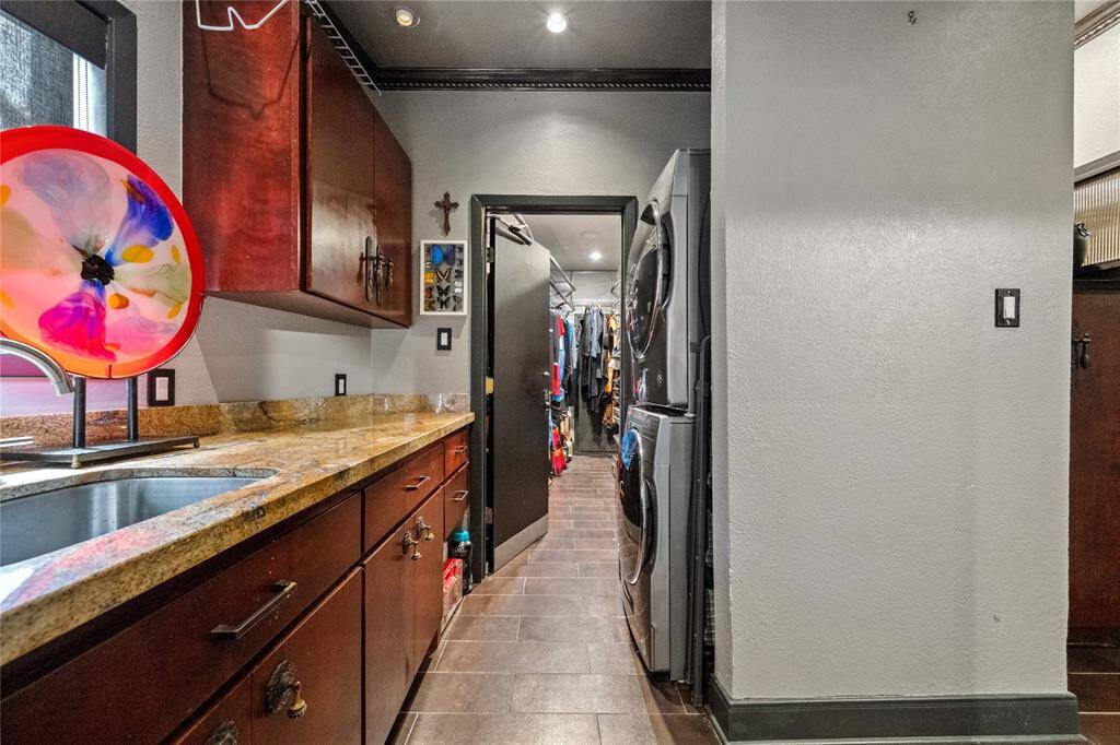 Utility room just off the primary suite features plenty of storage, sink and an extra closet.