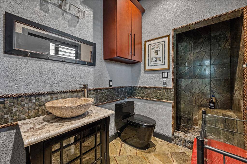 The bathroom in the Tree House guest apartment features a sleek stone shower, adding a touch of natural elegance.