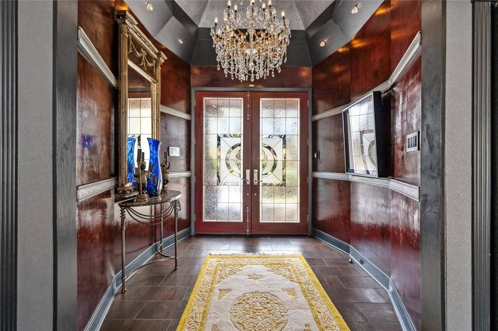 A stunning entryway featuring elegant glass doors that flood the space with natural light