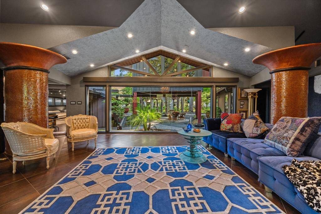 A sophisticated formal living space just off the entry, featuring a stunning wall of windows that frame picturesque views of the backyard and courtyard.
