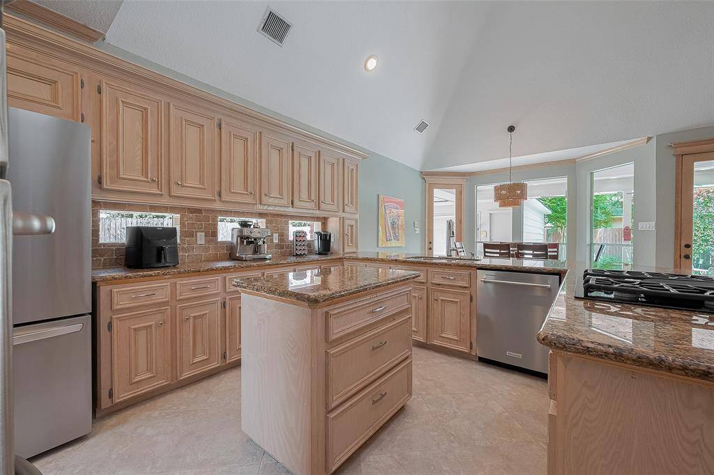 Travertine tiled backsplash along with transom windows bringing in the natural light.