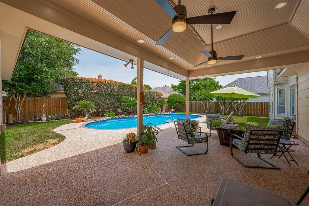 The ceiling on this covered patio are custom with wood trim.  Ceiling fans recently installed.  All of this overlooking the well landscaped backyard and pool.