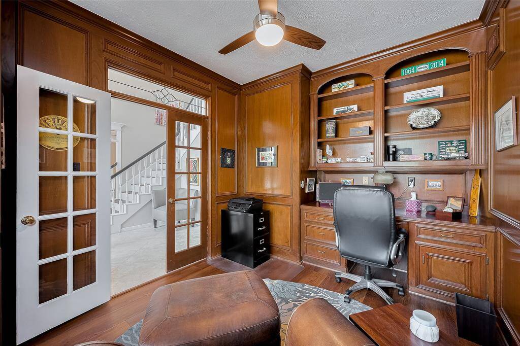 Rich, stained, hardwood paneling, custom built-ins and double glass French doors surround you in the private home study.