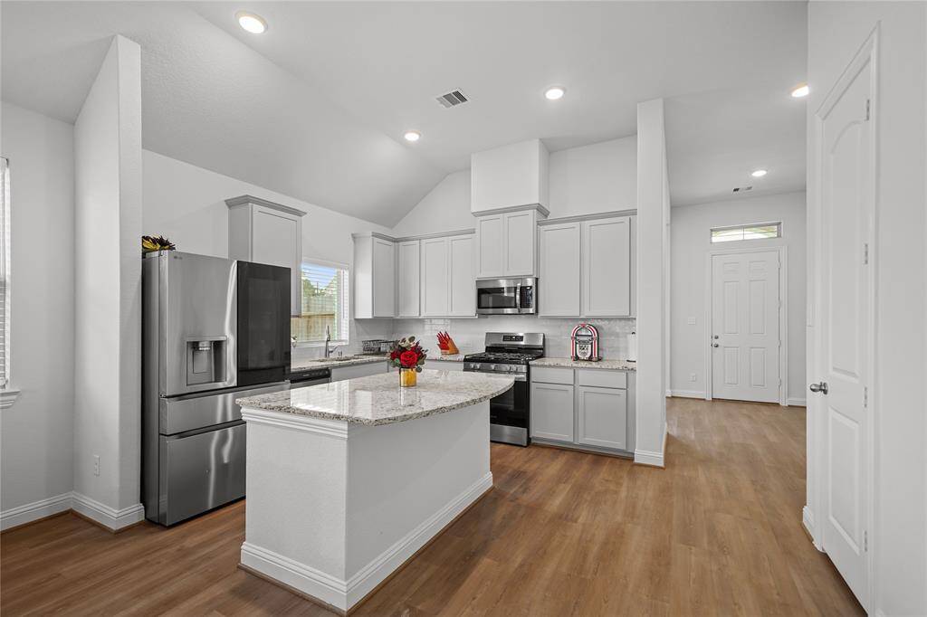 Kitchen has a Granite Island that provides plenty of Prep Space and a Breakfast Bar for Quick Meals.