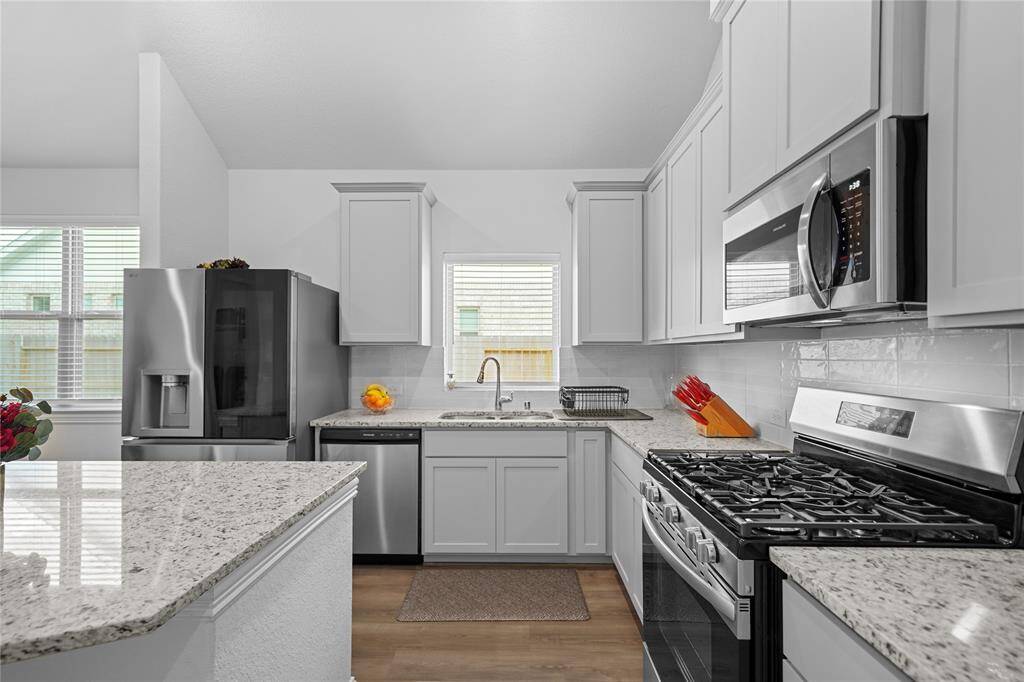 Kitchen features a Gas Range, Large Island & Granite Counters.